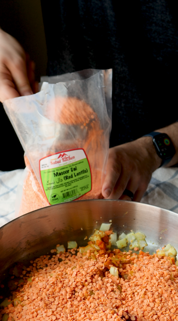 To make this creamy red lentil soup, begin by sautéing onions and minced garlic in oil. Then add carrots and seasonings. Cook for a few minutes, then add tomato paste, red lentils, and water. Bring to a boil, then cover and cook on super low for 30 minutes, or until lentils and carrots are soft. Blend until smooth, then add heavy cream. Add more heavy cream if a more soupy consistency is desired. Top with red pepper flakes and cilantro and enjoy!